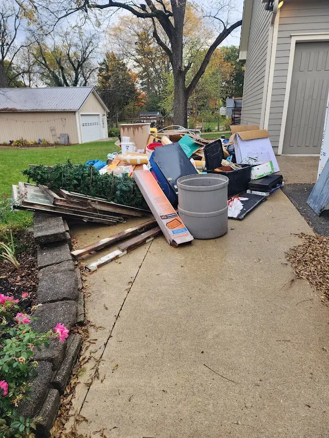 Dumpster being loaded with debris for 12 Yard Dumpster Rental in Throop